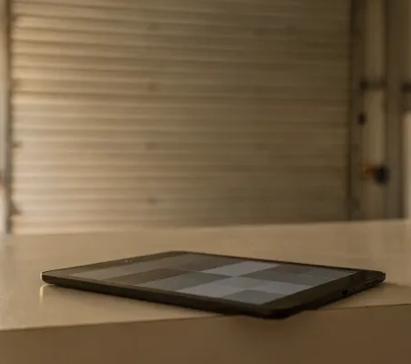 Tablet apoyada en el mostrador de recepción con la agenda del día en pantalla, antes de abrir la estación