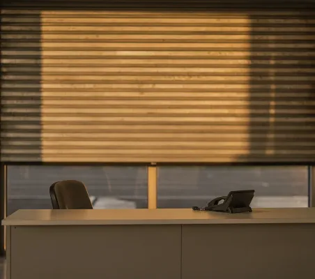 Mostrador de recepción vacío a última hora de la tarde con el teléfono fijo y la persiana a medio bajar